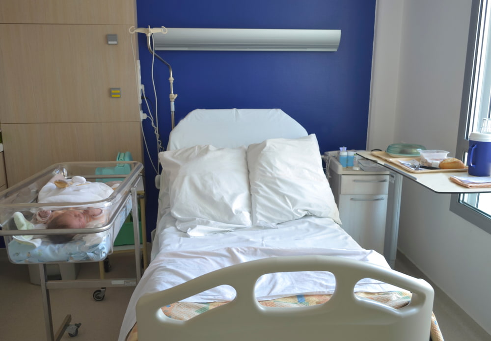 newborn in incubator inside a hospital room
