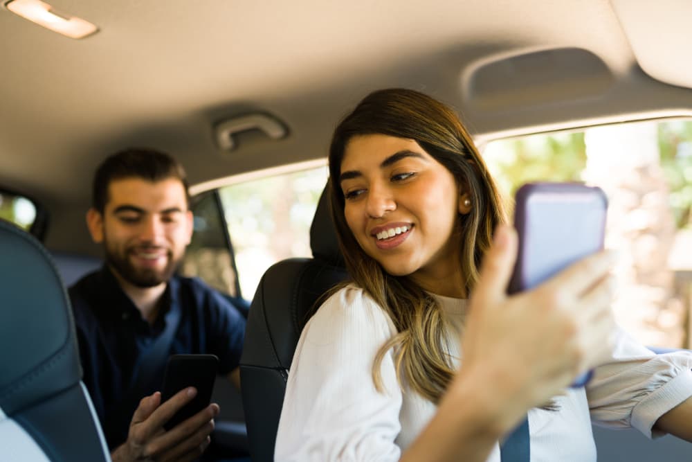 driver talking with a man in the back seat while driving.